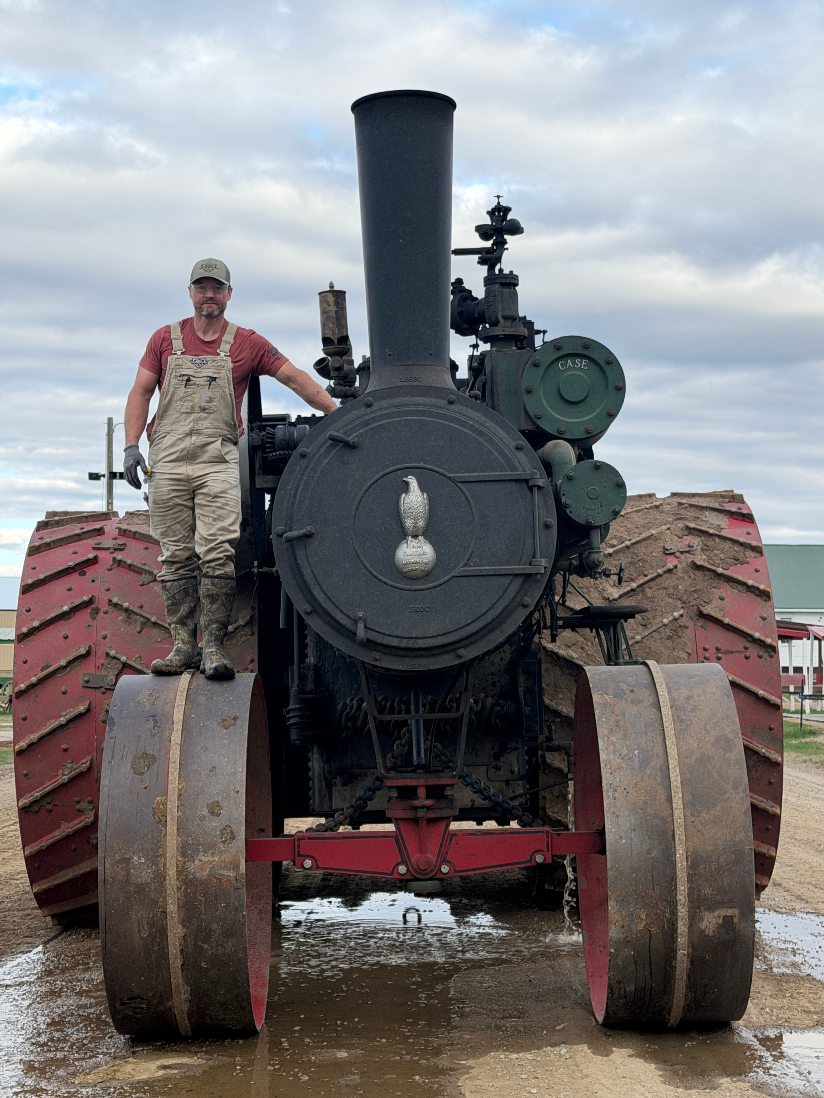 Person standing in front of the 150 HP Case boiler front, showing the engine's massive scale